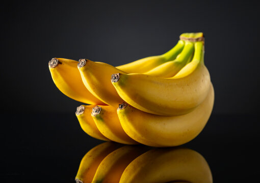 Bananas on a black reflective background.