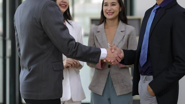 Business meeting handshake, Coworkers are discussing in the conference room. Colleagues clapped their hands to congratulate him on his success.