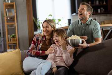 Family Movie Night: Engrossed in Thrilling Scenes at Home