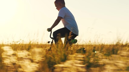 boy son legs are pedaling bicycle, child rolling bicycle sunset, happy family, child teen riding...