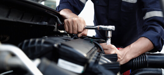 Mechanic are using the wrench to repair and maintenance auto engine at car repair shop,Car auto services and maintenance check concept.