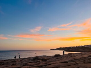 Orange sunset at the ocean, rocky ocean bay