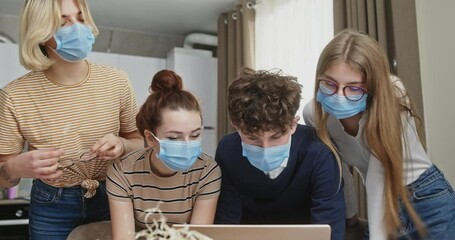 Dedicated Young Entrepreneurs in Masks Analyzing Data for Business Strategy - Powered by Adobe