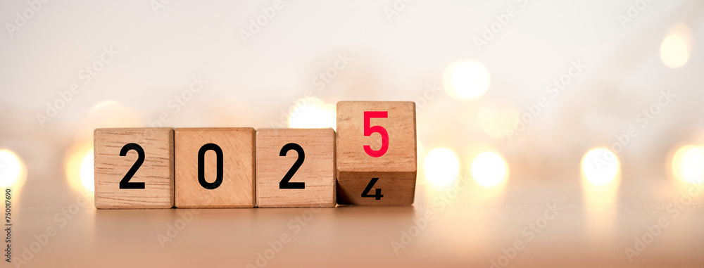 Poster flipping of 2024 to 2025 on wooden block cube with yellow light bokeh for preparation new year chang