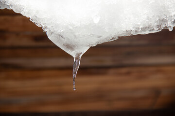 A small icicle hanging from the roof.