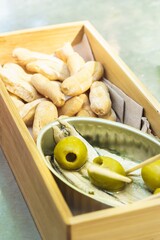 Spanish tapas. A can with some boquerones (anchovies) and olives along with some breadsticks.
