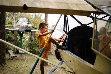 Kids having fun outside. Happy kids playing on climbing playground outside on bright day with green trees in background