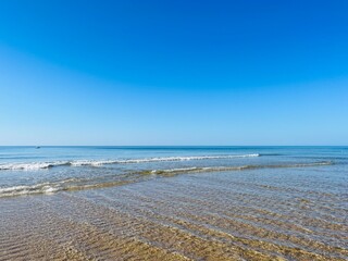 Transparent ocean water, ripples, sandy ocean coast, natural sea water background