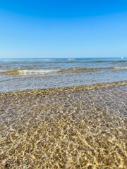 Transparent ocean water, ripples, sandy ocean coast, natural sea water background