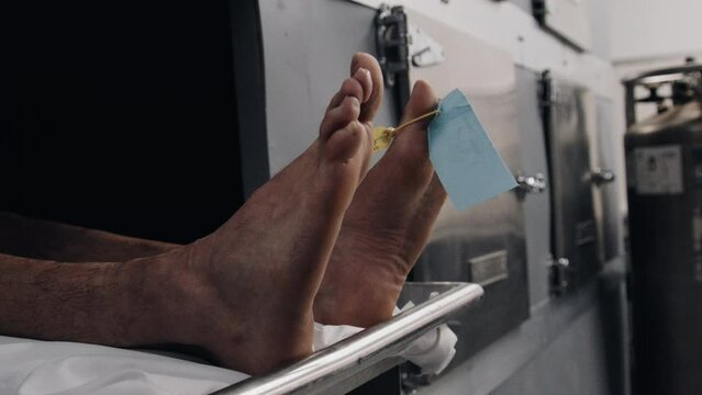 Feet in morgue cooler close up side profile