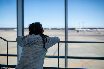 空港で窓の外を眺める女の子