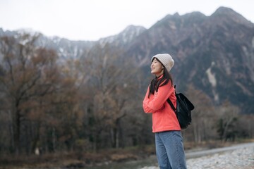 Fototapeta na wymiar Scenic journey, Asian woman in a pink fleece explores Japan's destination. Alone by the lake, an elegant portrait capturing the achievement, happiness, and joy of a trip.