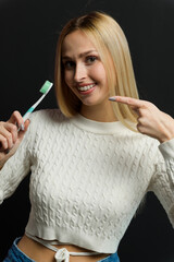 Young beautiful woman points her finger at the toothbrush. - 750020689