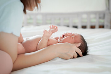 newborn male Is a person of Asian descent Lying in the bedroom on a white bed I'm crying.