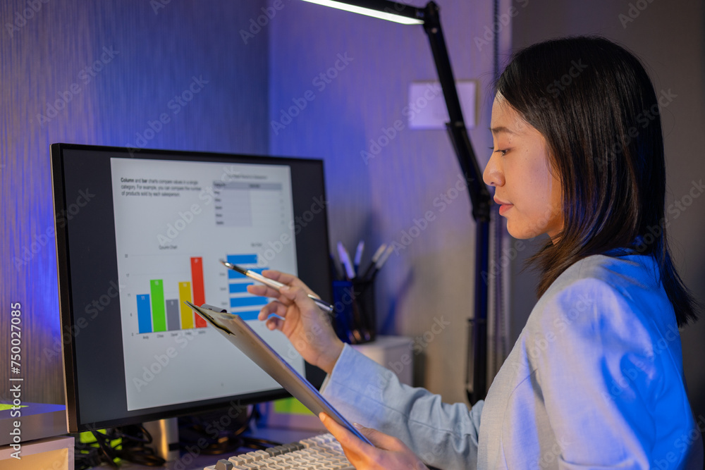 Wall mural An employee is working on a detailed graph that shows results reporting various results about the company, Check the graph report before submitting it to the supervisor according to the work schedule.