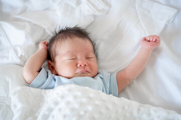 male newborn baby Is a person of Asian ethnicity Lying in the bedroom on a white bed