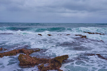 Waves and rocks - beginning of a tropic storm. Hurricane forming and climate change.