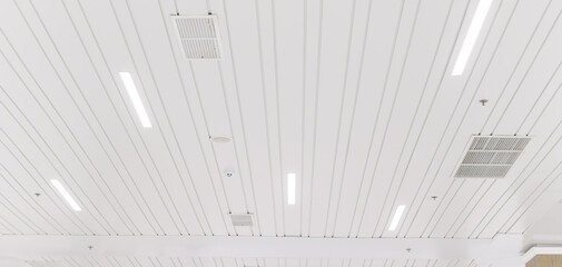 Ceiling mounted cassette type air conditioner and modern lamp light on a white ceiling. duct air conditioner for office or home