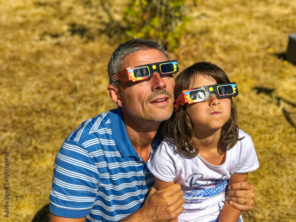 Sticker Father and daughter, family viewing solar eclipse with special glasses in a park