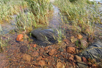 Small stones or boulders at a lake. Summer day. Vänern, Sweden 2023.
