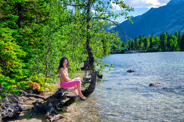 A happy woman reaxing along the lake in summer season