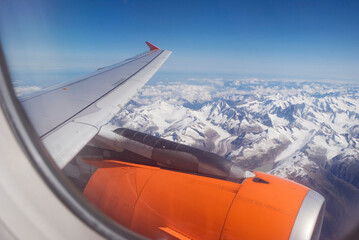 airplane flying over snowcapped mountains