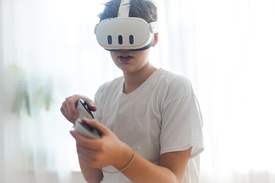 Teenage boy playing oculus console Meta Quest 3. Copy space. VR head set.