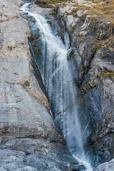small waterfall falling from a cliff in the mountains - 750055027