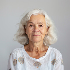 Portrait of a senior woman with a white studio background. Warm, friendly, and wise facial expression