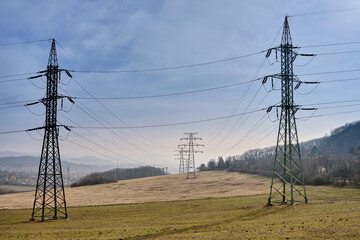 Old power grid transmission towers on agricultural land and pastures in a national park.  Rusty...
