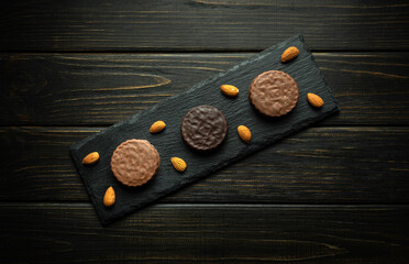 Chocolate cookies and almond on a serving black board. Low key concept of serving chocolate dessert...