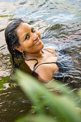 Hispanic woman submerged in a river in southern Colombia