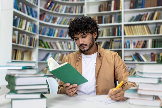 A dedicated student engrossed in reading a book, surrounded by piles of textbooks, diligently preparing for upcoming exams in the quiet atmosphere of a university library.