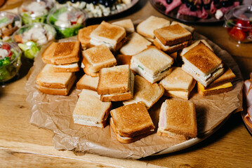 Assorted Sandwiches Platter for Catering. A platter of various sandwiches cut in halves, perfect for catering at parties, meetings, or events.