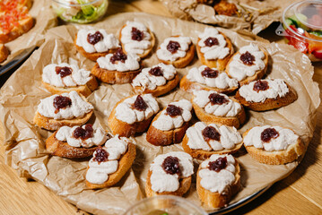 Tuna and Cream Cheese Crostini with Caramelized Onion. Crostini bites topped with whipped tuna and cream cheese blend, garnished with caramelized red onions, served on a tray.