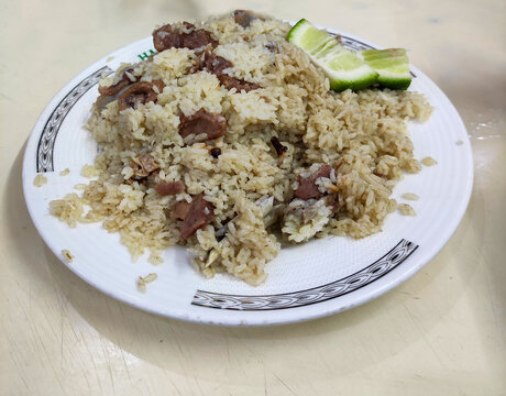 Old Dhaka famous Hanif Biriyani tehari a traditional  rice item of Bangladesh cooked with mutton, beef served in white bowl wooden background. 