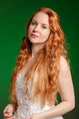 Beautiful red-haired young woman on a bright emerald green background - 750067242