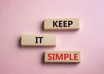 Keep it Simple symbol. Concept words Keep it Simple on wooden blocks. Beautiful pink background. Business and Keep it Simple concept. Copy space.