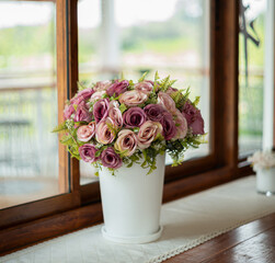 Fake flowers on a wooden table in coffee shop