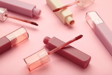 Beautiful lip glosses on a pink background - obrazy, fototapety, plakaty