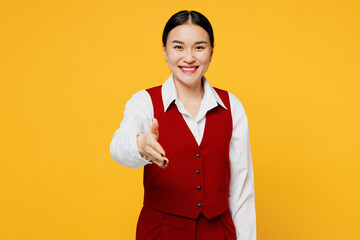 Young corporate lawyer employee business woman of Asian ethnicity in formal red vest shirt work at office hold hand folded handshake gesture isolated on plain yellow background studio Career concept