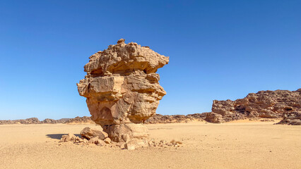 Tadrart landscape in the Sahara Desert, Algeria. This solitary block of sandstone appears to represent the profile of a comic or cartoon character. - 750082200