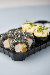 Close-up of sushi rolls made of sausage and covered with cabbage and ketchup. Homemade asian style. Sushi-food hybrids trend. Japanese food.