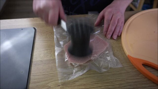 Schnitzel werden mit dem Fleischklopfer geklopft