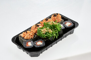 Close-up of sushi rolls made of sausage and covered with cabbage and ketchup. Homemade asian style. Sushi-food hybrids trend. Japanese food.