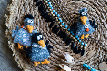 Obraz premium Knitted crows toy with yarn and knitting accessories