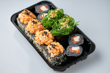 Close-up of sushi rolls made of sausage and covered with cabbage and ketchup. Homemade asian style. Sushi-food hybrids trend. Japanese food.