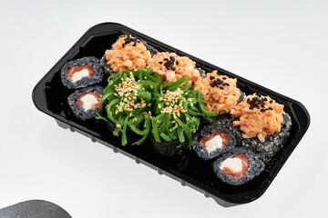 Close-up of sushi rolls made of sausage and covered with cabbage and ketchup. Homemade asian style. Sushi-food hybrids trend. Japanese food.
