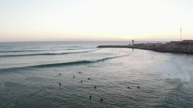 Aerial view of longboard surfers waiting at line up to surf at Atlantic Ocean, Imsouane, Morocco.