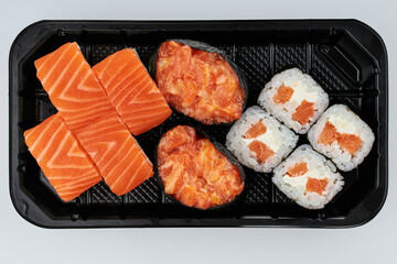 Close-up of sushi rolls made of sausage and covered with cabbage and ketchup. Homemade asian style. Sushi-food hybrids trend. Japanese food.